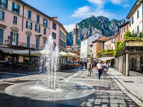Lecco,Lombardy,Italy-03 August 2014: The fountain in the Centre of Lecco.Some people walk through the town