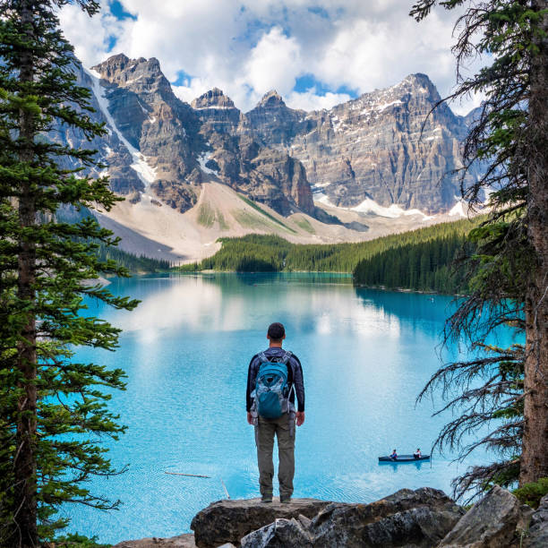 escursionista guardando la vista sul lago moraine nel banff national park, alberta, canada - canadian culture landscape mountain range mountain foto e immagini stock