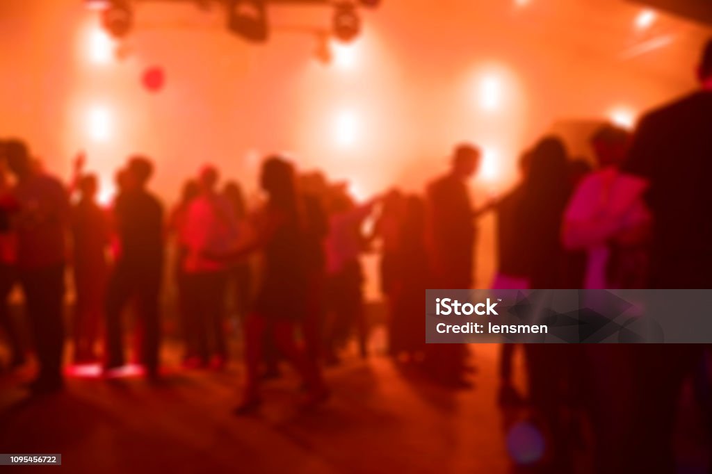 People Dancing at a Party Blurred shot of people dancing on the dance floor in a nightclub. Dance Floor Stock Photo