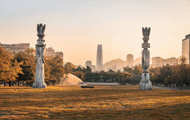 Santiago skyline at Araucano Park and chemamules traditional mapuche sculptures - Santiago, Chile Santiago skyline at Araucano Park and chemamules traditional mapuche sculptures - Santiago, Chile santiago chile photos stock pictures, royalty-free photos & images