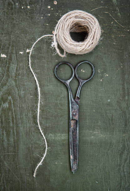 istock Old tailor scissors and rope hank on the wooden background 1095487592