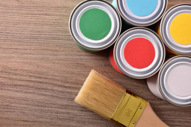 istock Colored paint pots and brush on wooden table top view 1095489494