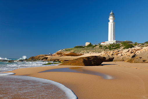 Lighthouse at the rough coastline of Cape Trafalgar, Province of Cádiz, Spain