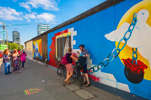 Berlin, Berlin state / Germany - 2018/07/30: The Wall Museum - East Side Gallery - exhibiting the remaining of the Berlin Wall with street art covering the east side of the construction along the Spree river