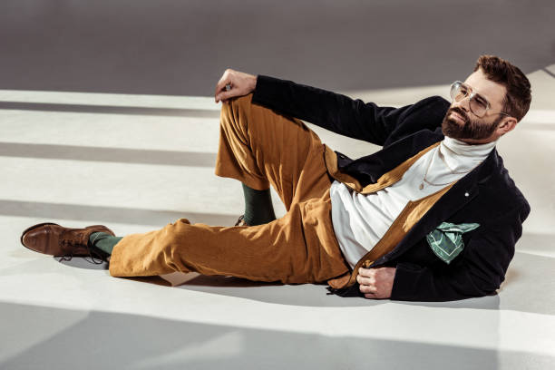 istock handsome stylish bearded man in glasses lying on floor 1095495290