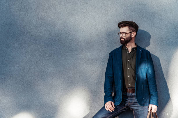 istock handsome bearded man in glasses and cap standing near wall 1095496380