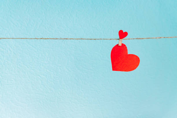 istock Love heart hanging on rope on a blue background 1095503434