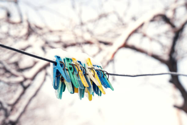 Plastic clothespins hanging on a wire in the freezing winter weather