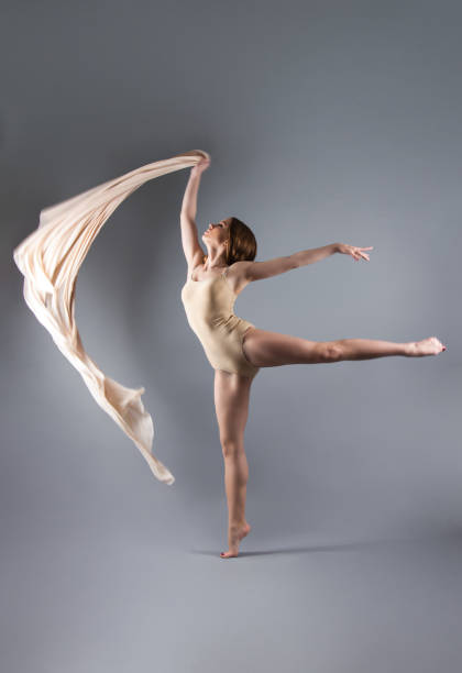 istock beautiful young girl dancing with cloth. Flying fluttering fabric. 1095517556