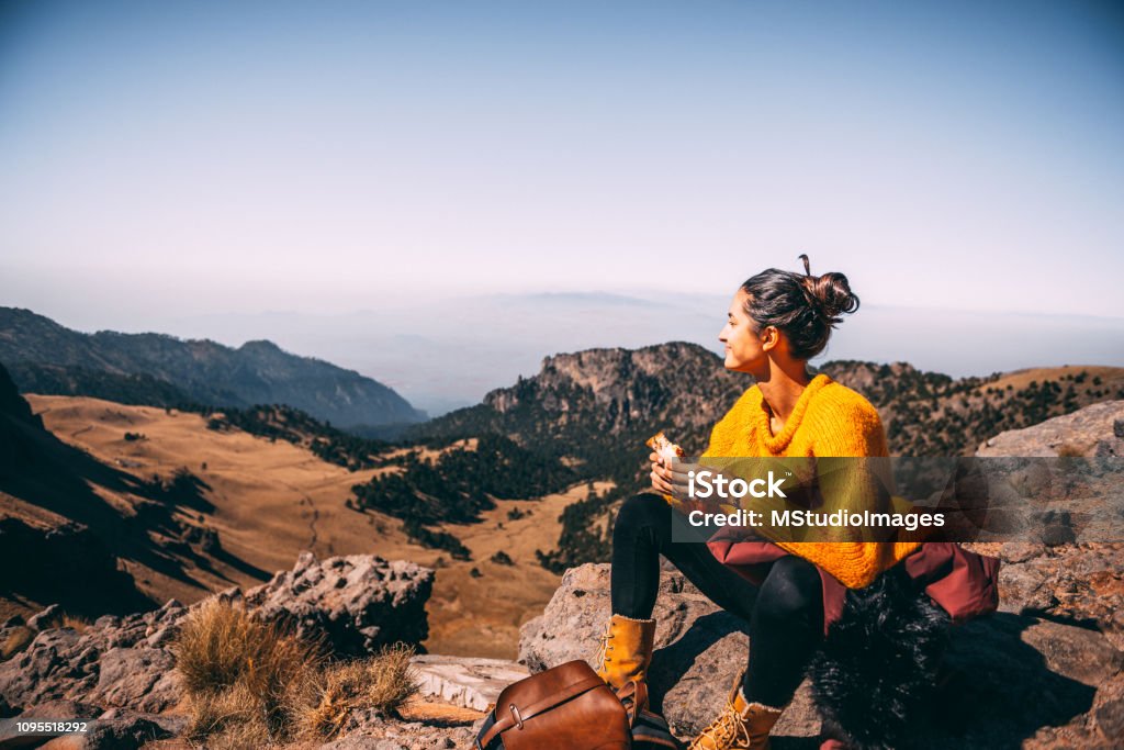 Lunch time. Tired Latin woman making a launch break. She is hiking at Popocatepetl volcano in Mexico Hiking Stock Photo
