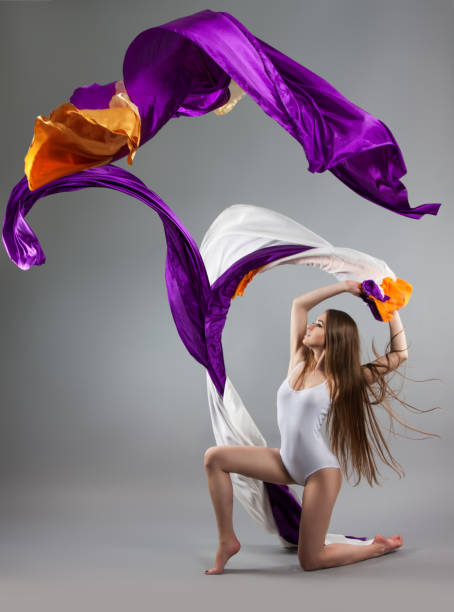 istock beautiful young girl dancing. Flowing fabric. 1095519376