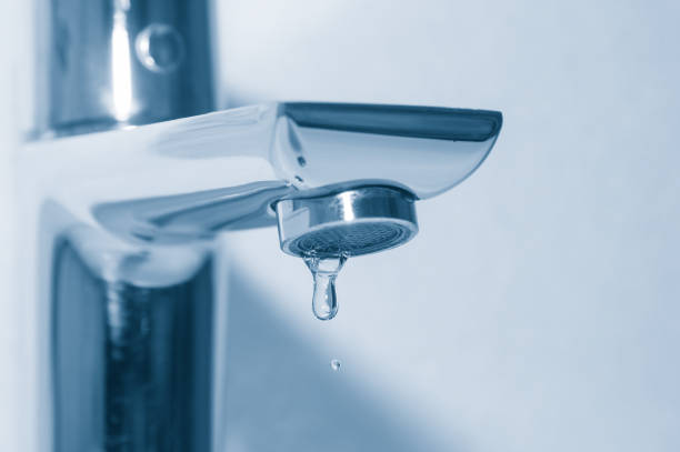 istock Metal tap and falling water drops close up 1095527168