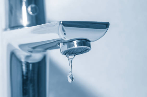 istock Metal tap and water drop close up on blue background 1095528086