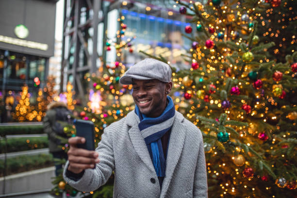 istock Smiling young businessman taking a selfie in front of a christmas tree 1095532264