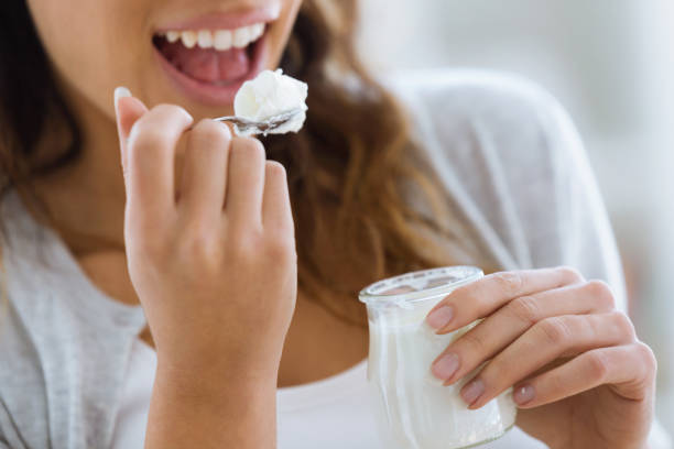 istock Woman's hand holding yogurt while eating at home. 1095536484