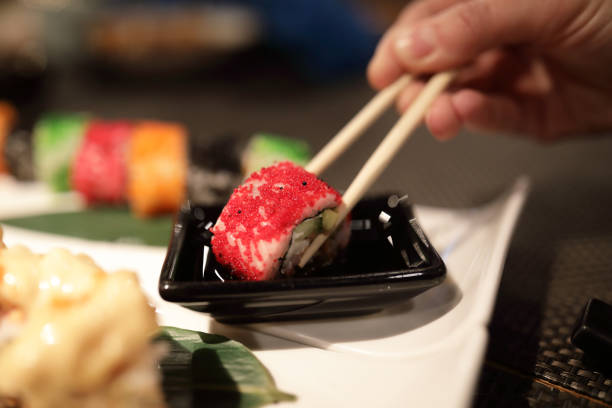 istock Person dipping sushi in soy sauce 1095537042