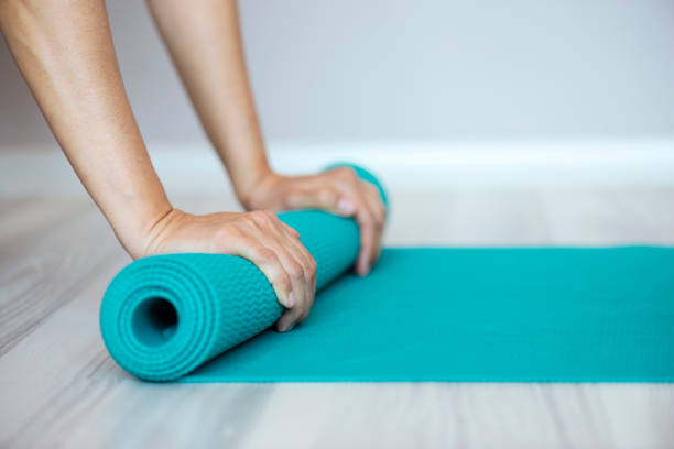 istock Woman Rolling Yoga Mat 1095537598