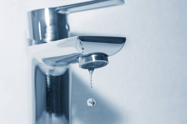 Tap with falling water drop close up