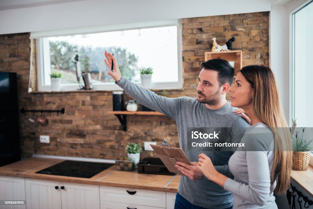 Couple talking about home renovation. Standing in the kitchen and discussing apartment renovation ideas. Kitchen Stock Photo