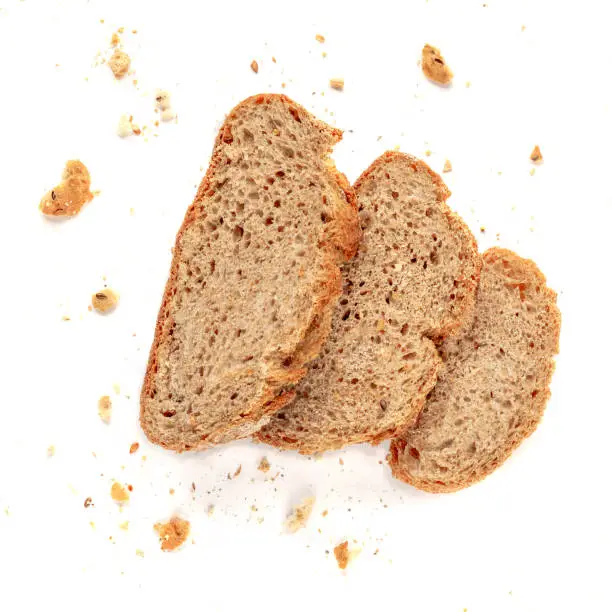 Three slices of toast bread with crumbs isolated on white background. Cutted wholegrain  bread. Top view
