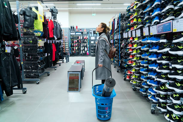 Woman shopping in a sport store, checking out of prices stock photo