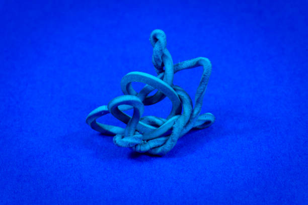 vecchio elastico intrecciato su blu con spazio di copia - flexibility rubber rubber band tangled foto e immagini stock