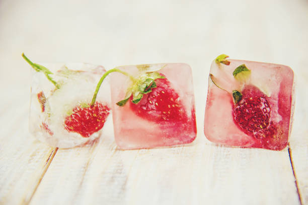 Berries frozen in ice cubes. Selective focus.