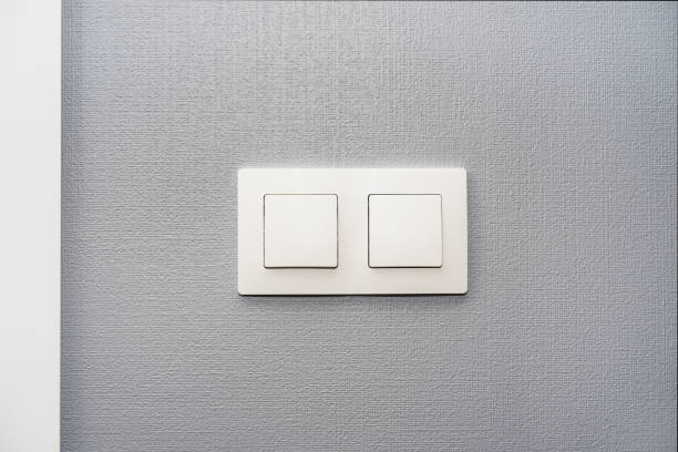 istock a light switch, a plastic mechanical switch of white color installed on a light gray wall in the room 1095574984