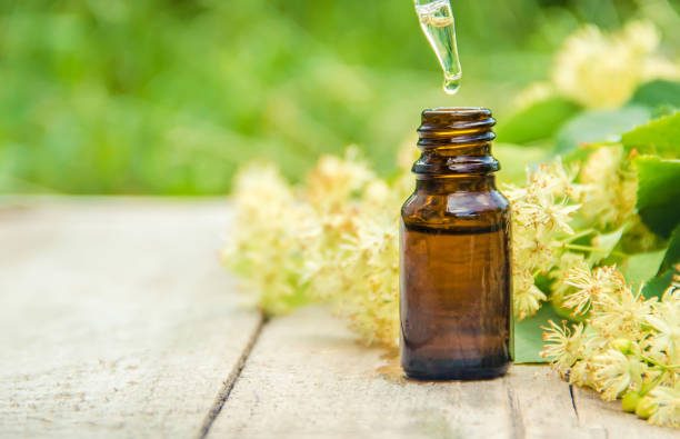 istock linden extract and flowers in a small bottle. Selective focus. 1095575612