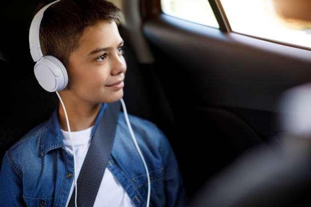 adolescente escuchando música en el coche - seat belt audio fotografías e imágenes de stock