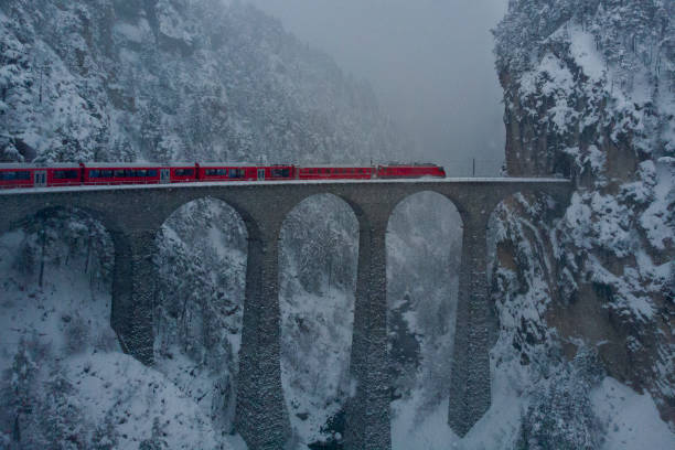 geleira de trem vermelho exoress a nevasca sobre landwasserviadukt na suíça - graubunden canton fotos - fotografias e filmes do acervo