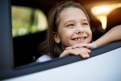 Portrait of happy smiling little child sitting in the car