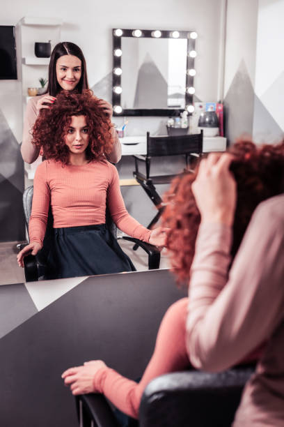 istock Pleasant red haired woman looking at herself in the mirror 1095594432