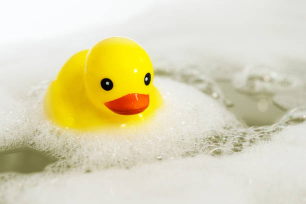istock One yellow rubber duck with soap bubble bath, light  background with bubbles. Kids spa concept. Children`s bath time concept. 1095595276