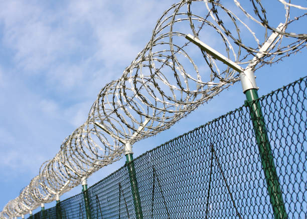 istock Barbed wire fence on state border or restricted area. 1095596264