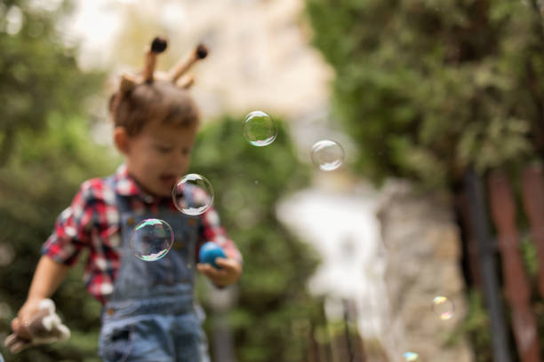 Soap Bubbles In Focus And A Boy Out Of Focus In The Garden
