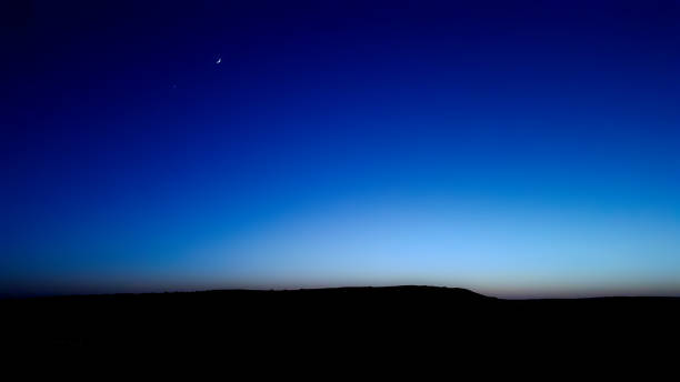 istock Blue hour sky scene with the moon and a star at dawn time. 1095606652