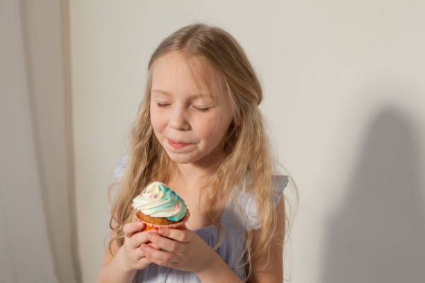istock small girl in hand holds a sweet cupcake cake 1095608468