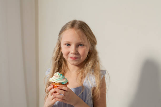 istock small girl in hand holds a sweet cupcake cake 1095608558