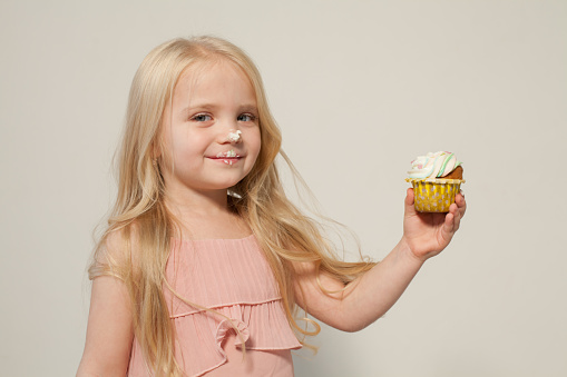 small girl in hand holds a sweet cupcake