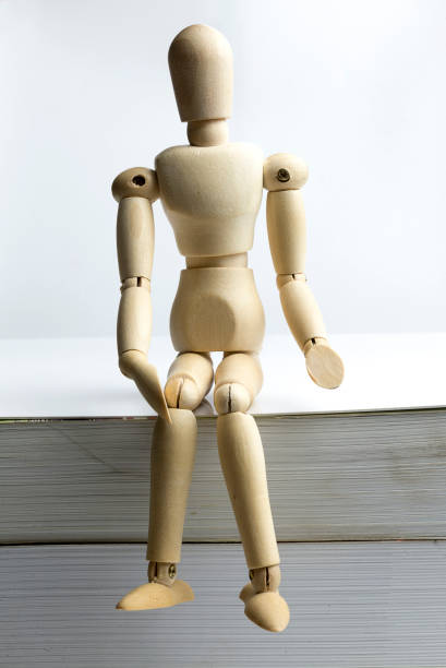 istock Wooden man sits on books. 1095612846