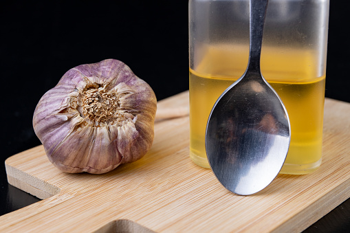 Garlic and medicinal juice for colds. Home remedies for colds. Dark background.