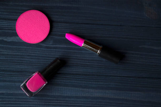 istock Pink cosmetics on a dark blue wooden background. 1095618598