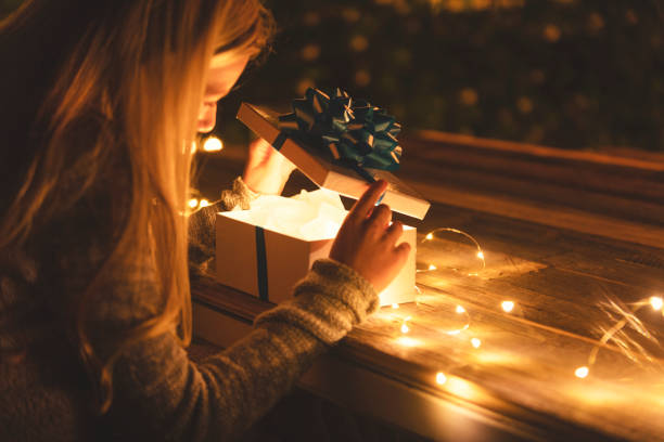 istock Woman opening a gift box. There is a glow coming from the box. 1095621212