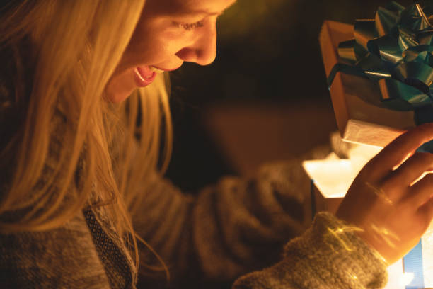 istock Woman opening a gift box. There is a glow coming from the box. 1095621214