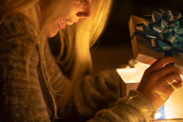 istock Woman opening a gift box. There is a glow coming from the box. 1095621222