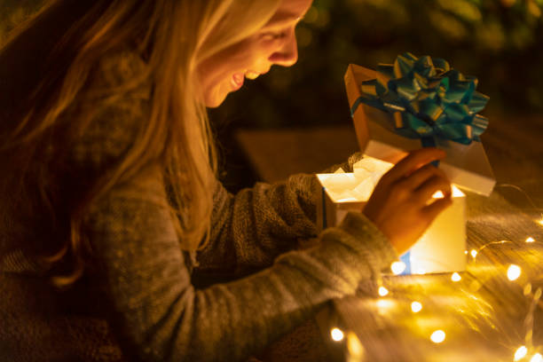 istock Woman opening a gift box. There is a glow coming from the box. 1095621224