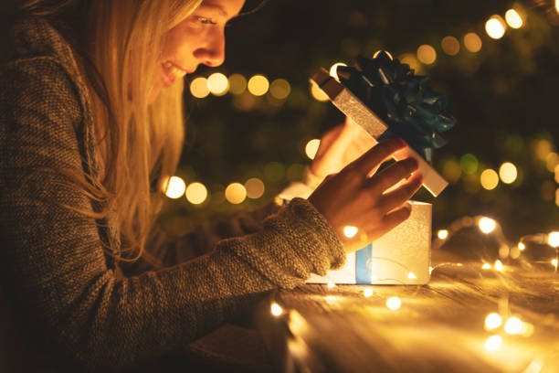 istock Woman opening a gift box. There is a glow coming from the box. 1095621226