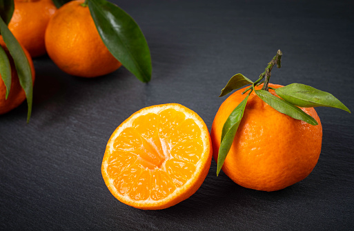 delicious mandarines/oranges  on a black stone plate / slab