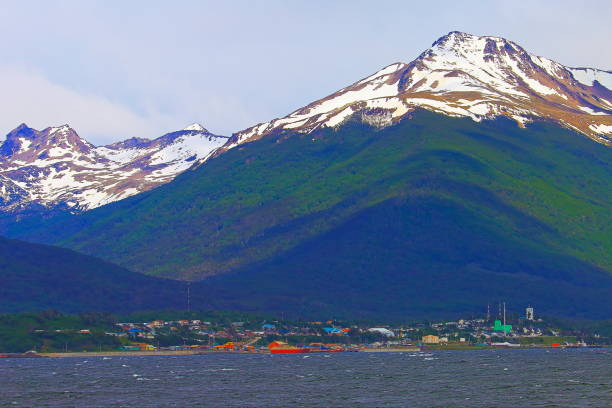 Beagle channel and Dientes de Navarino mountain range, Puerto Williams - Chile Beagle channel and Dientes de Navarino mountain range, Puerto Williams - Tierra Del fuego, Chile, border with Argentina – South America

Puerto Williams (Spanish for "Port Williams") is a Chilean village, port and naval base located on Navarino Island facing the Beagle Channel. It is the capital of the Chilean Antarctic Province, one of four provinces located in the Magellan and Chilean Antarctica Region, and administers the communes of Chilean Antarctic Territory and Cabo de Hornos. It has a population of 2,874, including both naval personnel and civilians. Puerto Williams claims the title of world's southernmost city.
Dientes de Navarino (Teeth of Navarino in English) are a mountain range in Navarino Island, Chile, located just south of Puerto Williams, along the Beagle Channel coast. They are named for the jagged pinnacles which resemble teeth.
There is a rough hiking circuit around the range. Depending on weather conditions the trek takes 5 to 7 days. beagle channel stock pictures, royalty-free photos & images